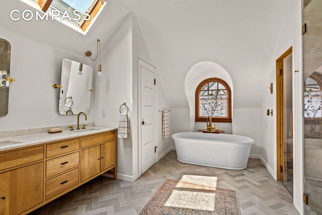 1221 Albemarle Rd, New York City, NY 11218 - bathroom featuring a skylight, lofted ceiling, double vanity, a freestanding tub, and baseboards