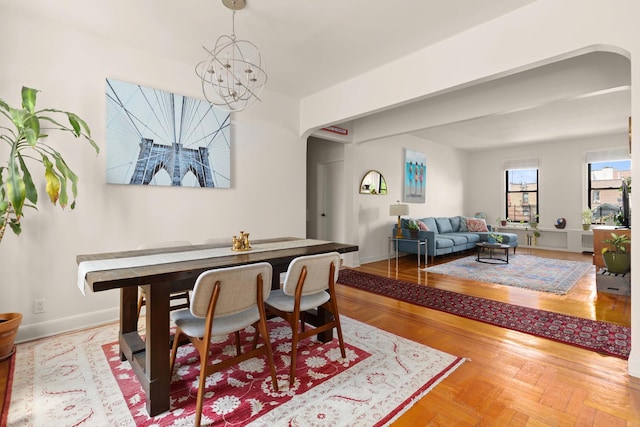 80 Winthrop St Unit 4C, New York City, NY 11225 - dining room with arched walkways, a chandelier, and baseboards