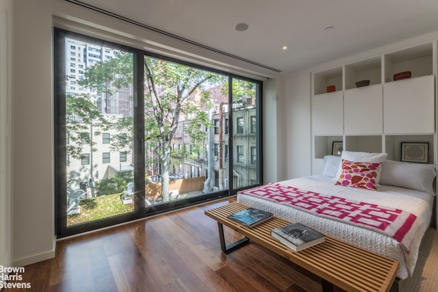 251 E 61st St, New York City, NY 10065 - bedroom featuring multiple windows, floor to ceiling windows, and wood finished floors