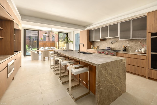 48 W 85th St, New York City, NY 10024 - kitchen featuring a sink, modern cabinets, tasteful backsplash, and a breakfast bar area