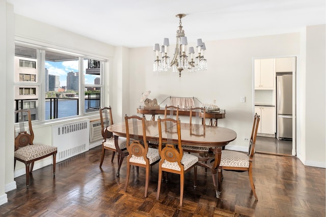 dining area with radiator heating unit, a chandelier, and baseboards