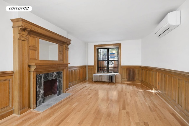 425 Convent Ave, New York City, NY 10031 - additional living space with radiator heating unit, an AC wall unit, wainscoting, light wood-type flooring, and a fireplace