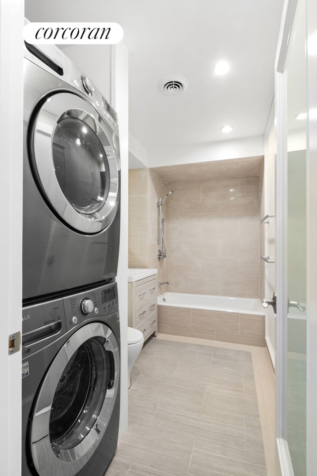 425 Convent Ave, New York City, NY 10031 - laundry room with stacked washing machine and dryer, light tile patterned floors, and recessed lighting