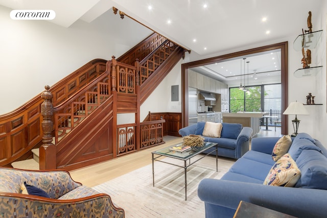 425 Convent Ave, New York City, NY 10031 - living area featuring light wood-style flooring, recessed lighting, stairway, wainscoting, and electric panel