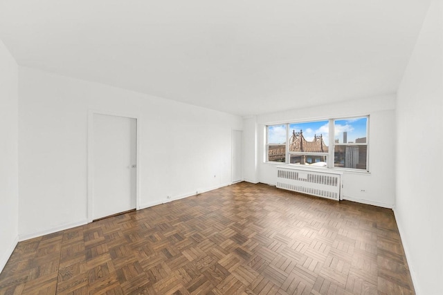 spare room with radiator and baseboards