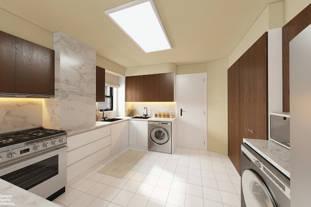kitchen with washer / dryer, stainless steel gas range oven, and a sink