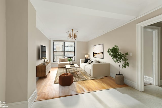 living area with ornamental molding, wood finished floors, baseboards, and a chandelier