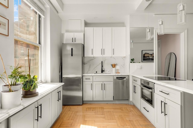 kitchen featuring stainless steel appliances, plenty of natural light, light countertops, and decorative backsplash