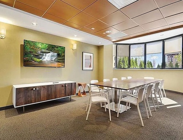 dining room featuring baseboards, dark colored carpet, and a paneled ceiling