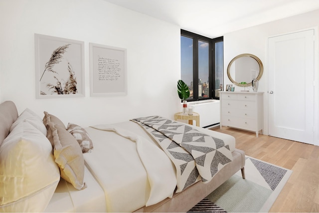 bedroom with wood finished floors and radiator heating unit