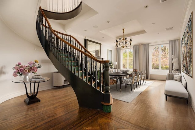 243 E 17th St, New York City, NY 10003 - stairway with a tray ceiling, a chandelier, wood finished floors, and baseboards