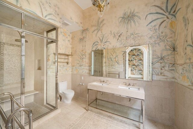 243 E 17th St, New York City, NY 10003 - bathroom featuring wallpapered walls, a shower stall, toilet, wainscoting, and double vanity