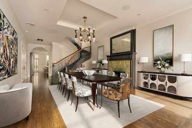 243 E 17th St, New York City, NY 10003 - dining area with stairs, arched walkways, wood finished floors, a tile fireplace, and ornamental molding