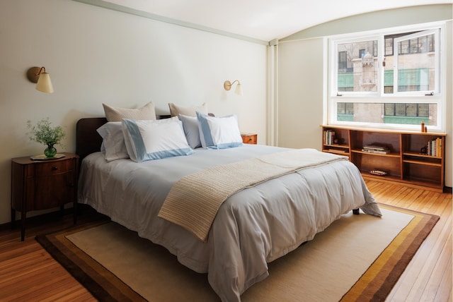 bedroom featuring hardwood / wood-style floors and lofted ceiling