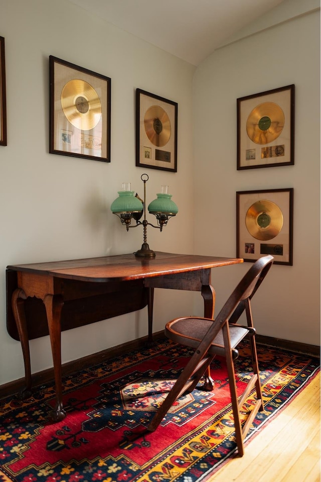 home office with baseboards and wood finished floors
