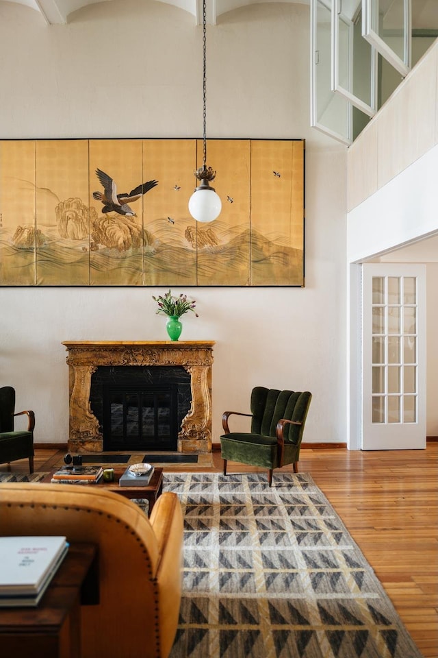 living room with wood finished floors and a fireplace with raised hearth