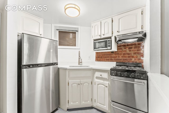 331 E 92nd St Unit 1A, New York City, NY 10128 - kitchen with appliances with stainless steel finishes, ventilation hood, light countertops, and white cabinets