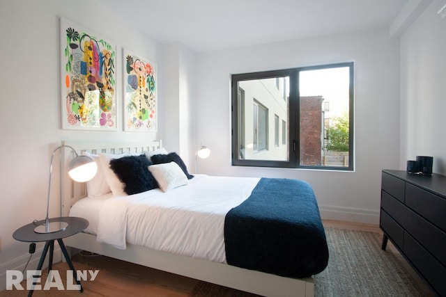 bedroom with wood finished floors and baseboards
