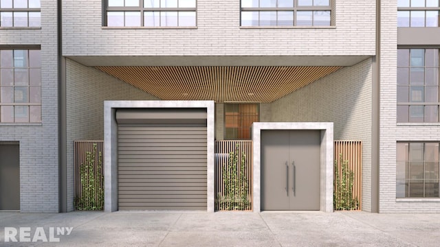 doorway to property with brick siding, a gate, and fence