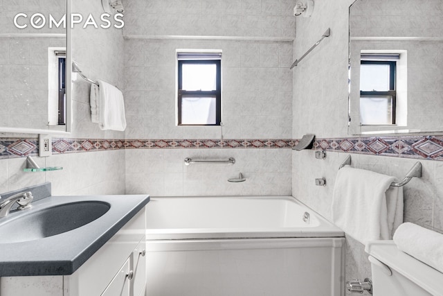 bathroom featuring tile walls, a bathtub, toilet, and vanity