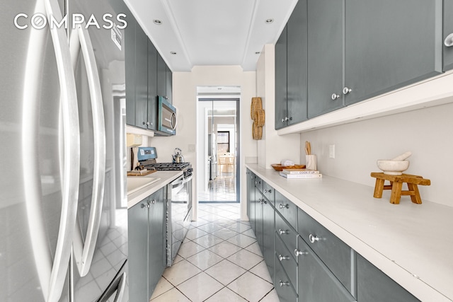 345 E 52nd St Unit 10Cd, New York City, NY 10022 - kitchen with appliances with stainless steel finishes, light countertops, light tile patterned floors, and gray cabinetry