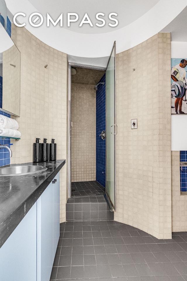 345 E 52nd St Unit 10Cd, New York City, NY 10022 - full bath with tile patterned flooring, tile walls, vanity, and a stall shower