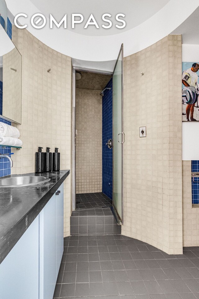 345 E 52nd St Unit 10Cd, New York City, NY 10022 - full bath with tile patterned floors, tile walls, vanity, and a shower stall