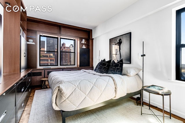 345 E 52nd St Unit 10Cd, New York City, NY 10022 - bedroom featuring wood finished floors and multiple windows