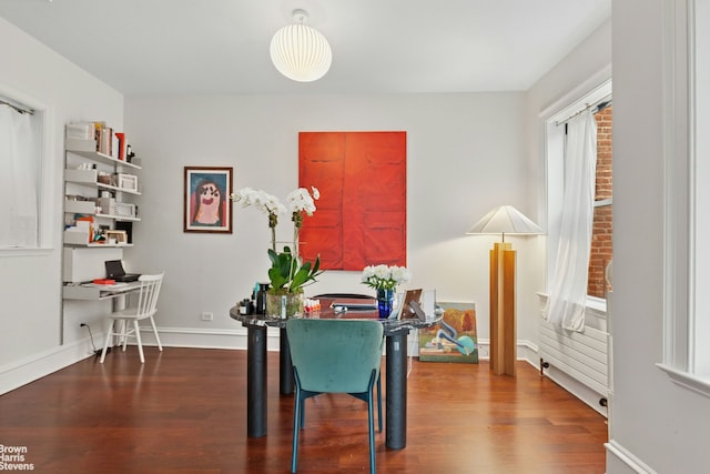 dining room featuring wood finished floors, an office area, and baseboards