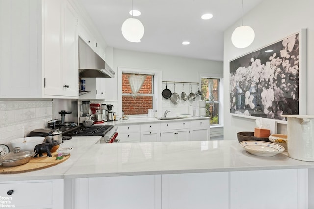 kitchen featuring under cabinet range hood, a sink, decorative backsplash, white cabinets, and recessed lighting