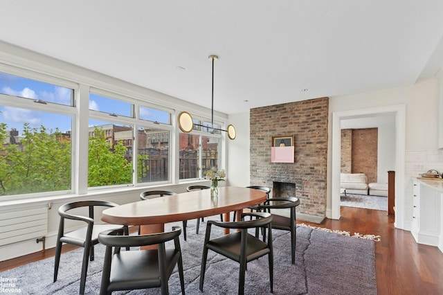 dining area with plenty of natural light, dark wood finished floors, and a fireplace