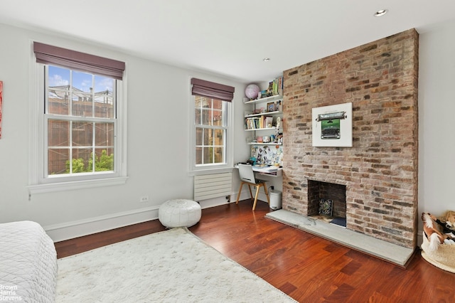 sitting room featuring wood finished floors, a fireplace, baseboards, and recessed lighting