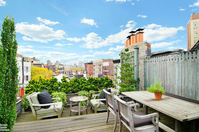 deck with outdoor dining area and a city view