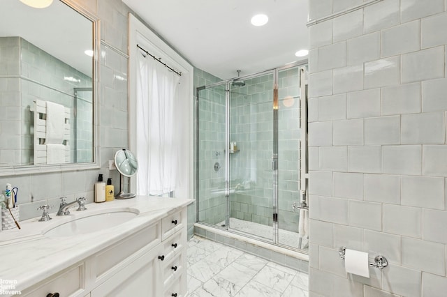 bathroom with a shower stall, vanity, marble look tiles, and recessed lighting