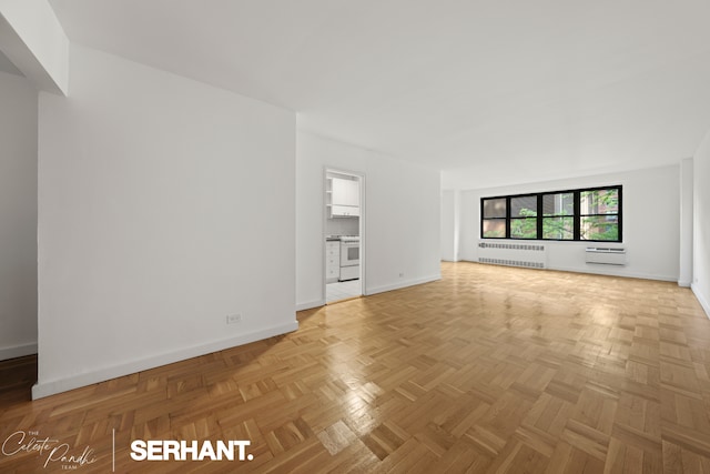 301 E 63rd St Unit 3B, New York City, NY 10065 - unfurnished living room featuring radiator heating unit, a wall unit AC, and baseboards