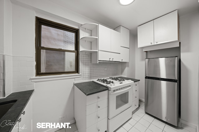301 E 63rd St Unit 3B, New York City, NY 10065 - kitchen featuring freestanding refrigerator, white range with gas stovetop, white cabinets, and decorative backsplash