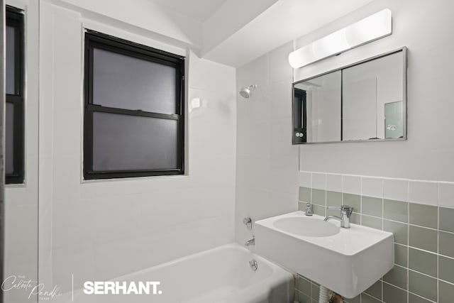301 E 63rd St Unit 3B, New York City, NY 10065 - full bathroom with bathing tub / shower combination, a sink, and tile walls