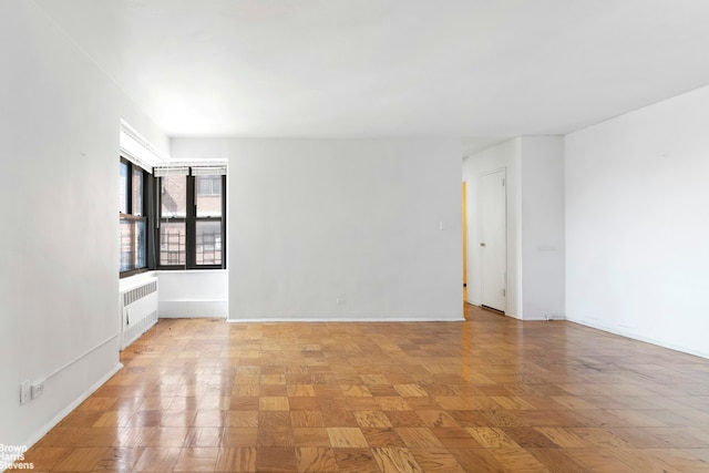 210 E Broadway Unit H1401, New York City, NY 10002 - spare room featuring radiator and baseboards