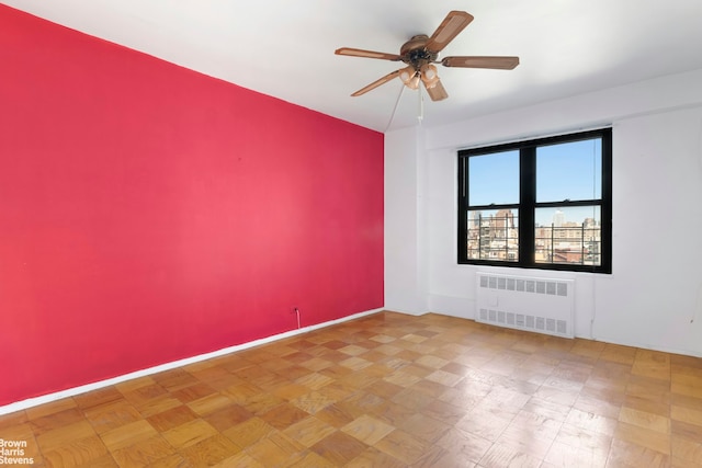 210 E Broadway Unit H1401, New York City, NY 10002 - spare room with radiator heating unit, a ceiling fan, and baseboards