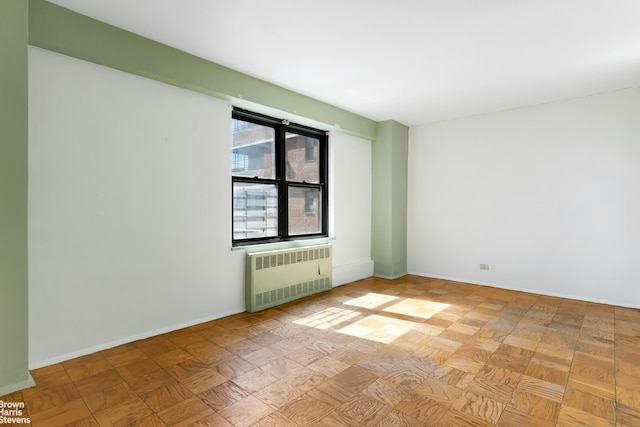 210 E Broadway Unit H1401, New York City, NY 10002 - spare room featuring radiator heating unit and baseboards
