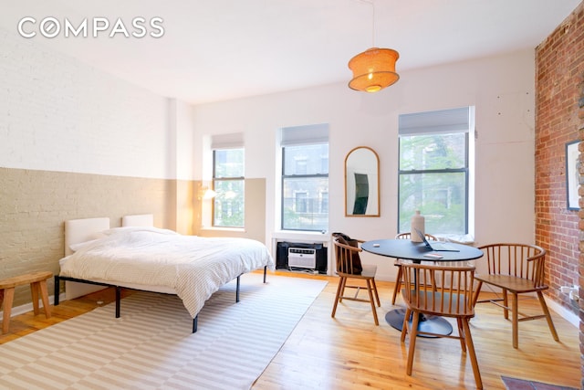 349 W 71st St, New York City, NY 10023 - bedroom featuring wood finished floors, brick wall, a wall unit AC, and a fireplace