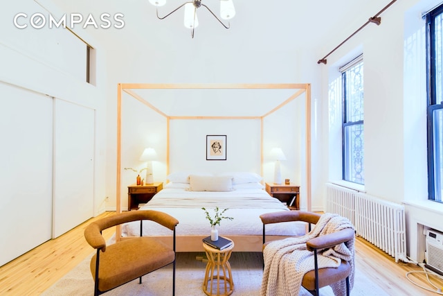 349 W 71st St, New York City, NY 10023 - bedroom with radiator heating unit, wood finished floors, a chandelier, and a closet
