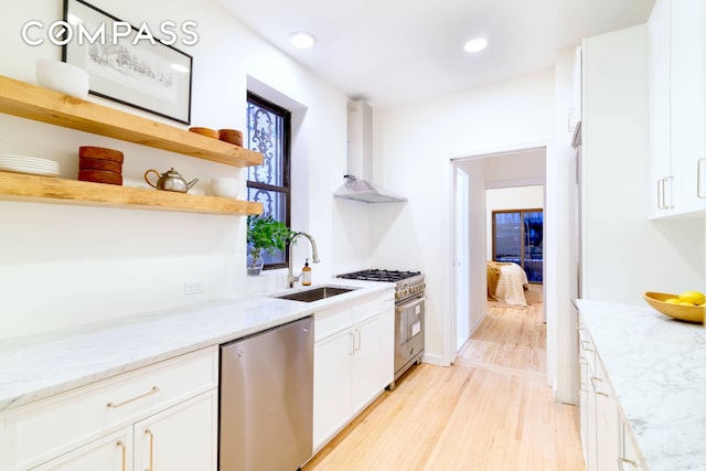 349 W 71st St, New York City, NY 10023 - kitchen featuring stainless steel appliances, open shelves, a sink, wall chimney range hood, and light wood-style flooring
