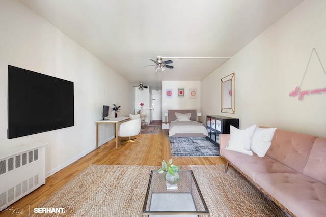 430 E 77th St Unit 4B, New York City, NY 10075 - living area featuring radiator, wood finished floors, a ceiling fan, and baseboards