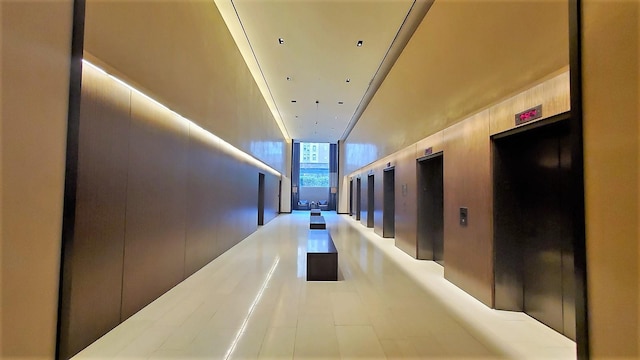 hallway with elevator and tile patterned floors