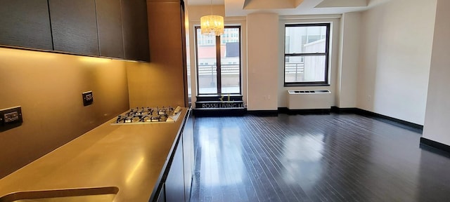 unfurnished room with a chandelier, baseboards, radiator, and dark wood finished floors