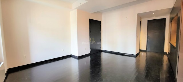 empty room featuring wood finished floors and baseboards