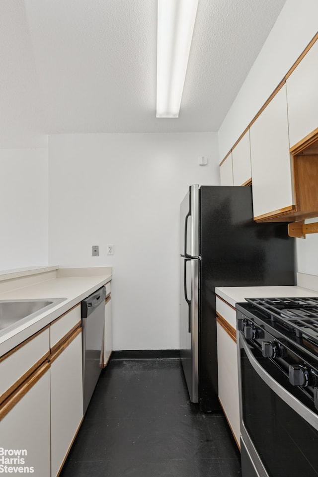 kitchen featuring dishwasher, gas stove, white cabinetry, and light countertops