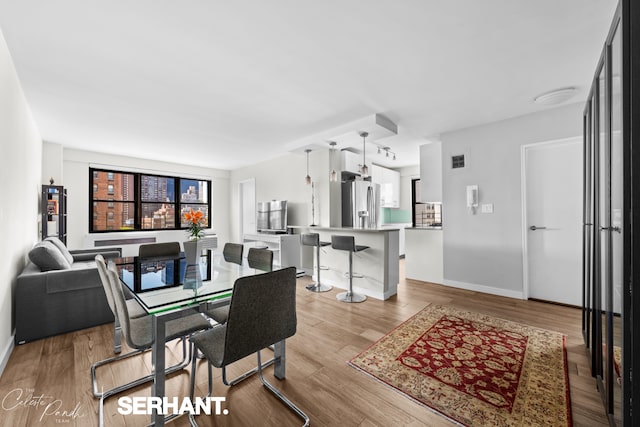 dining area featuring baseboards and wood finished floors