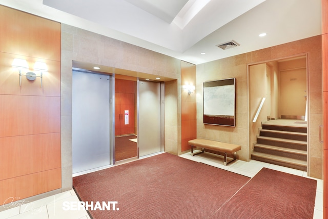 community lobby featuring tile walls, recessed lighting, and stairs